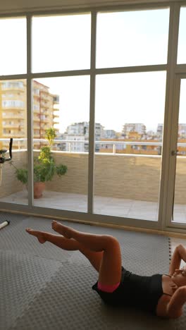 mujer haciendo ejercicios abdominales en casa