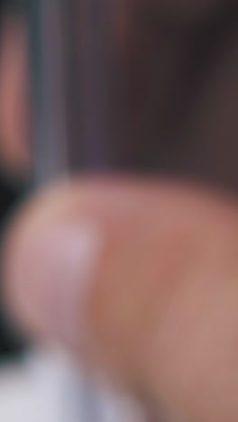 young person shakes new blue ball pen in transparent case on blurred background extreme close view