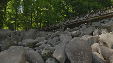 felsenmeer in odenwald sea of rocks with bridge wood nature tourism on a sunny day pan shot