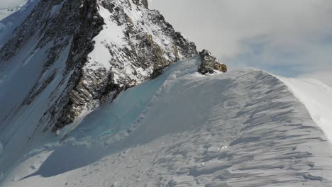 4k drone footage of jagged mountain ridgeline and blue glacial ice