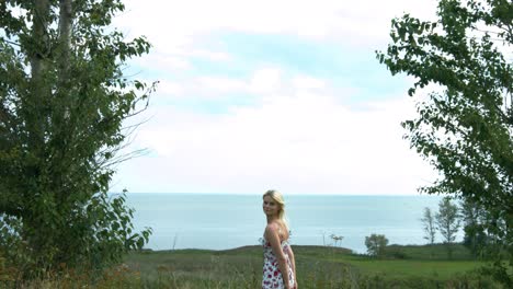 Una-Joven-Y-Bella-Mujer-Rubia-Admirando-La-Naturaleza-Y-Corriendo-Alegremente-Hacia-La-Cámara