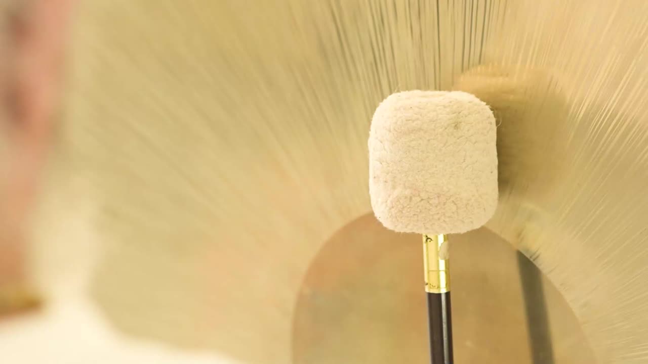 Crop spiritual practitioner with hammer playing gong