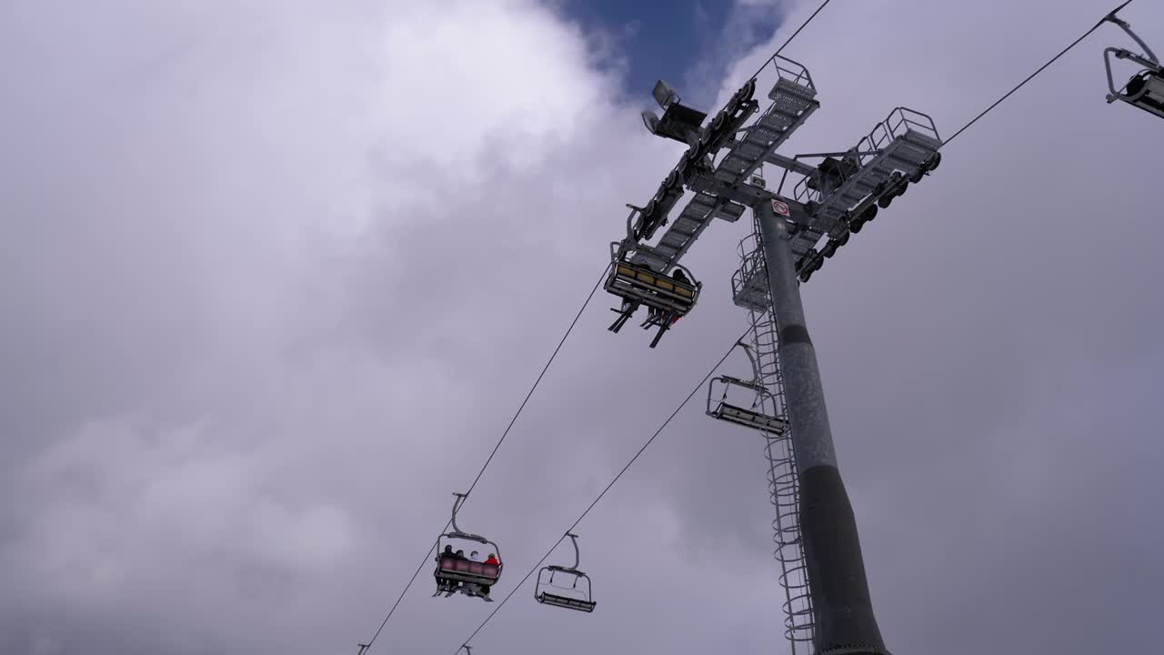 ascensor de esquí con esquiadores sobre un fondo de cielo azul y nubes. estación de esquí