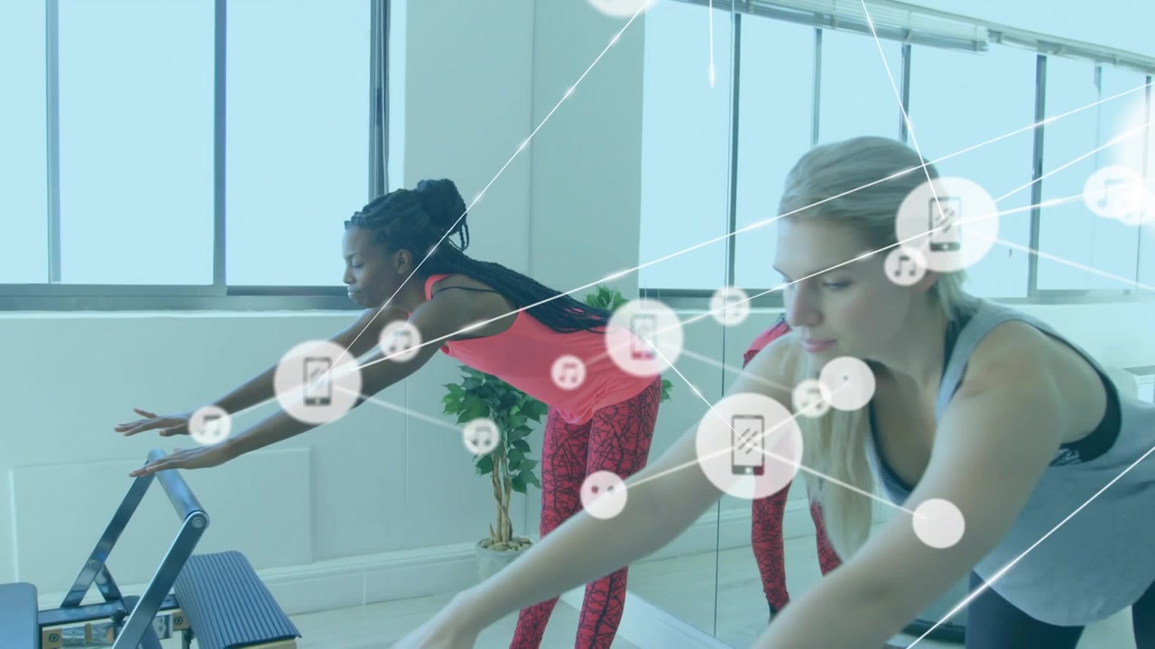 Animation of icons connected with lines over diverse females exercising in yoga studio
