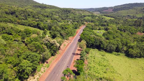 Aerial-view-captures-a-pathway-in-Misiones,-Argentina,-winding-through-native-woodlands-and-open-fields,-illustrating-the-diverse-and-scenic-landscape-of-the-region