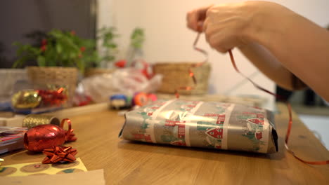 wrapping christmas gift with red tape