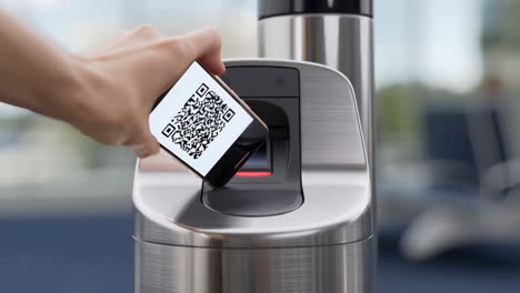 a hand holding a smartphone with a qr code being scanned by a reader