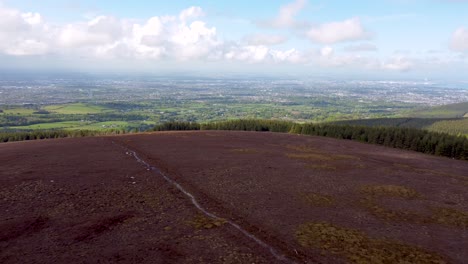 Fliegen-über-Den-Gipfel-Des-Berges-Mit-Der-Stadt-Im-Hintergrund---Dublin,-Irland