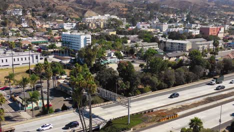 a drone aerial of southern california beach town of ventura california with freeway foreground and mountains background 2