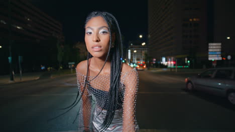 dreadlocks girl staring lens at night lights traffic road portrait. lady posing