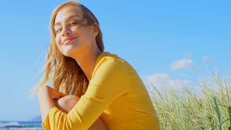 zijbeeld van een jonge blanke vrouw die ontspant op het strand 4k