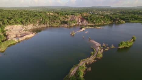 Drone-Volando-Sobre-Un-Lago-Y-Un-Camino-De-Tierra