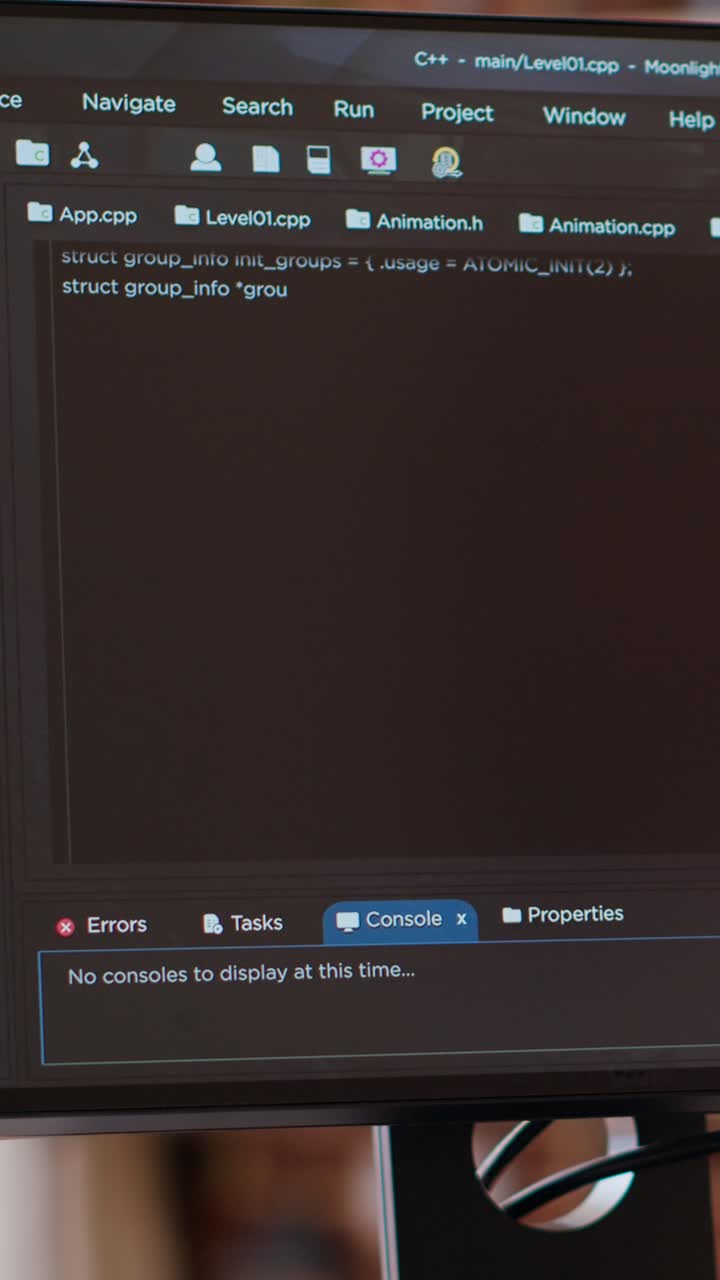 Vertical Video Asian programmer seen typing code for a user interface design on dual monitors