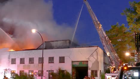firefighters battle blaze at night in urban setting