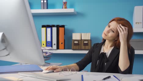 tired business woman gets upset when she sees the computer and continues her work.