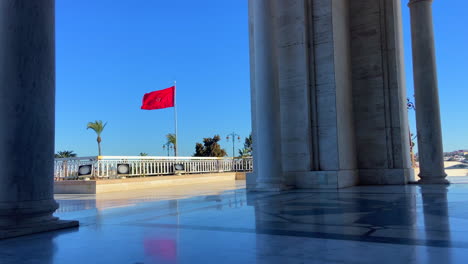 moroccan flag waving across the mausoleum of mohammed v in rabat