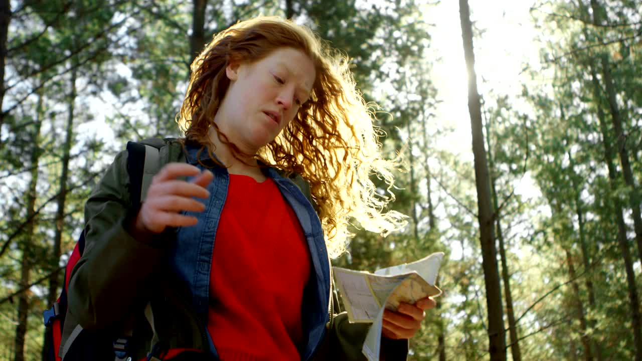 mujer mirando el mapa en el bosque 4k