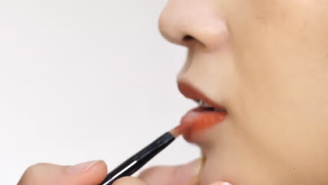 professional young girl with lots of makeup brushes, surrounded by a variety of cosmetics, eyeshadows and lipsticks