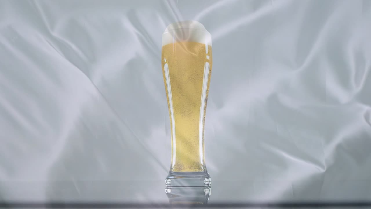 Ondulations de tissu projetant des lumières sur un verre de bière, créant des reflets chatoyants et des variations de couleur qui révèlent la bière.