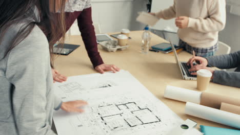 mujer arquitecta mostrando planes para el equipo de negocios de inicio hipster
