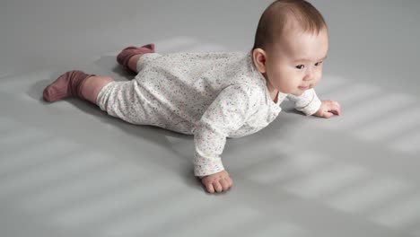 a five month old infant baby girl lying on her stomach