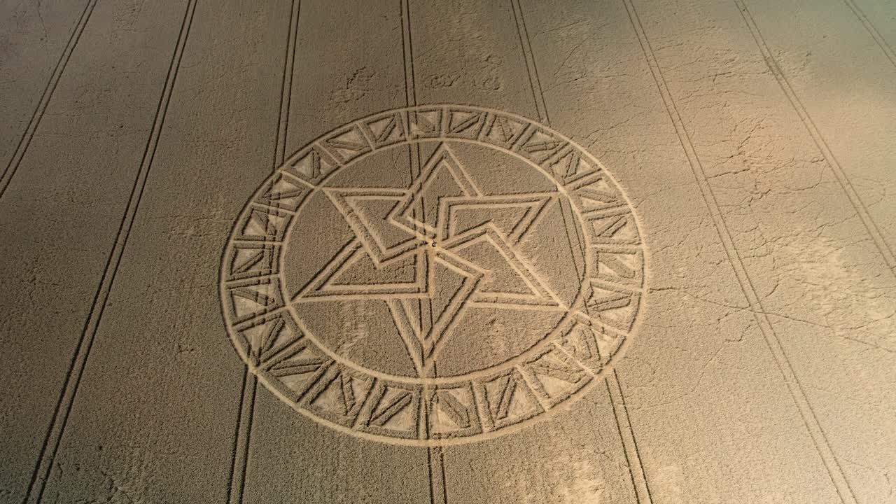 Mysterious West Meon golden barley field crop circle pattern aerial view descending towards design