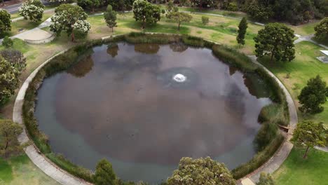 Aerial-Tilt-Down-View-Over-Circular-Lake-With-Fountain---Perth,-Australia