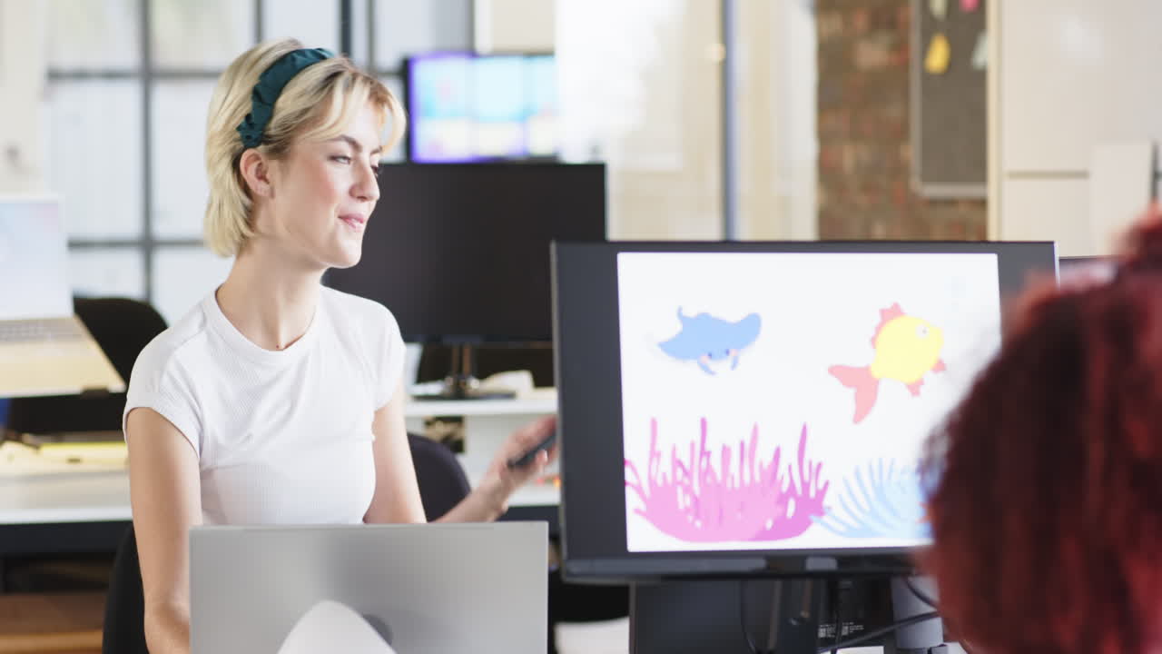 Talking on phone, woman with laptop smiling at animated fish on computer screen