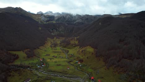 Paradise-Alpine-village-on-valley-surrounded-by-trees-forest-and-rocky-mountains-in-Autumn,-Lepushe-Albania