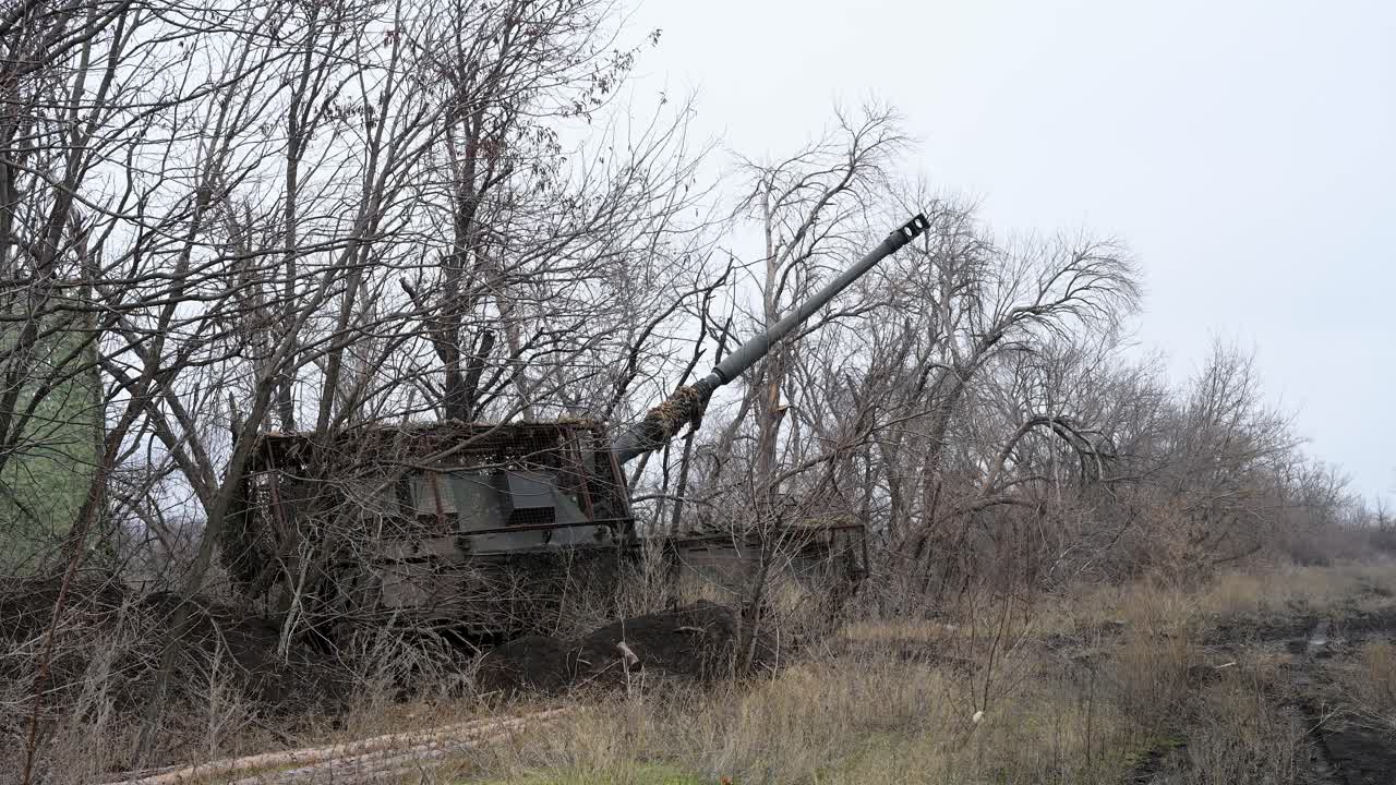Un obice PzH 2000 di fabbricazione tedesca in una posizione di tiro mimetizzata in Ucraina, il suo lungo cannone elevato verso il fronte russo. Una scena dai duelli di artiglieria della guerra