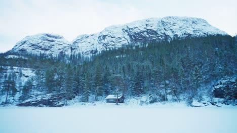 Rocky-Mountains-And-Forest-With-Cottage-During-Winter-Season