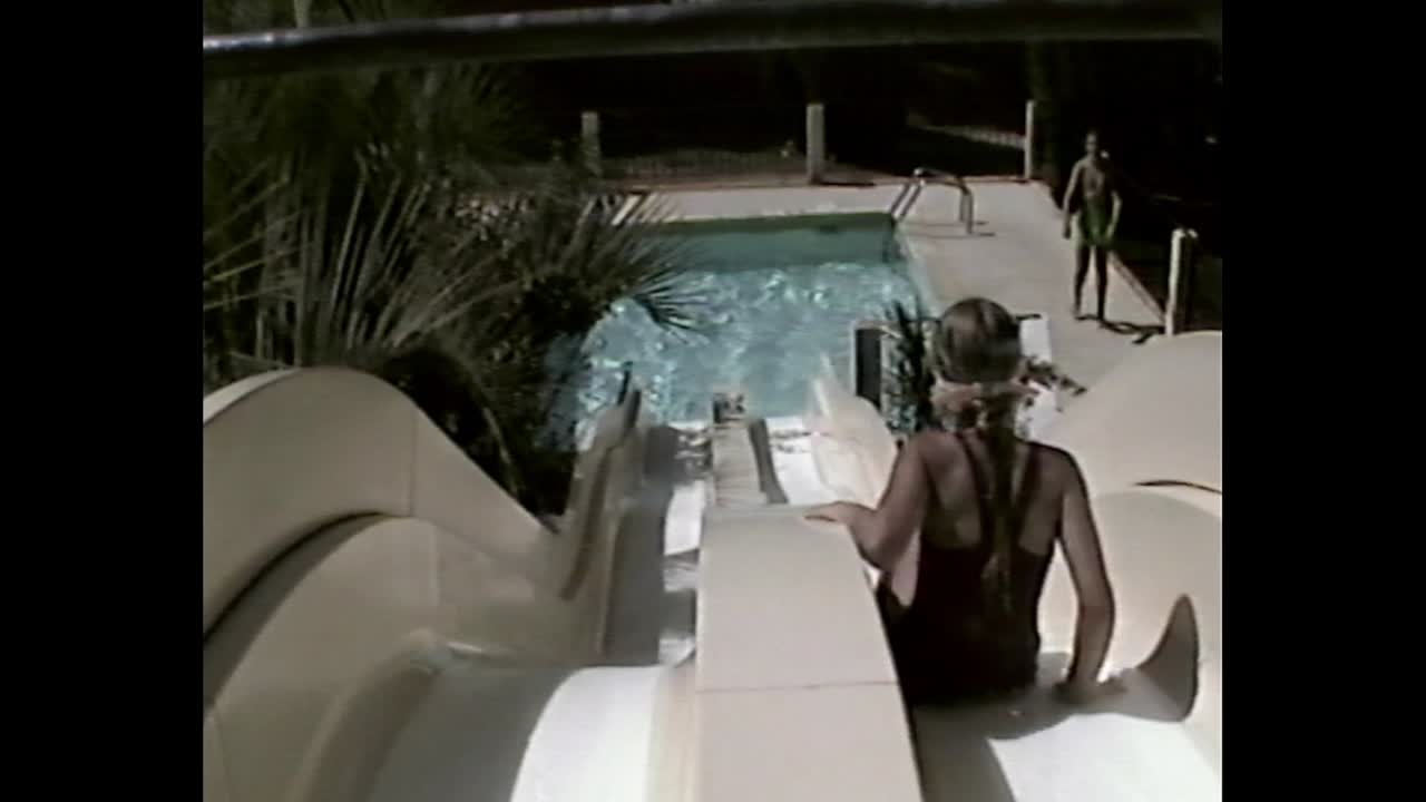 Kids having fun at a water slide and swimming pool