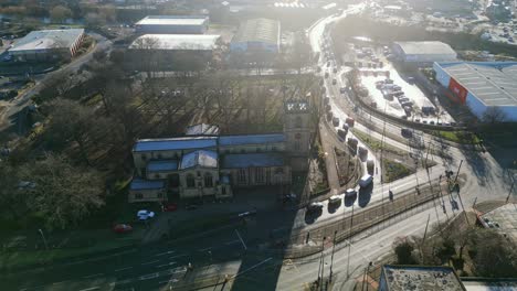 Cinematic-aerial-footage-of-a-old-industrial-town-in-Yorkshire-England-showing-church-industrial-estate,-and-busy-town-with-traffic-and-roads