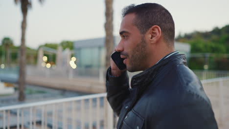 young man calling on smartphone outdoors.