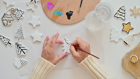 woman hand paints christmas ornaments