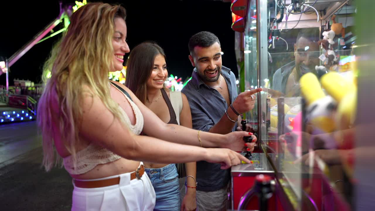Friends Playing Claw Machine at Carnival