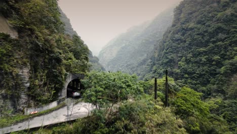 car travelling along remote mountainous area road steep river valley with tunnels in taiwan taroko unfinished provincial highway