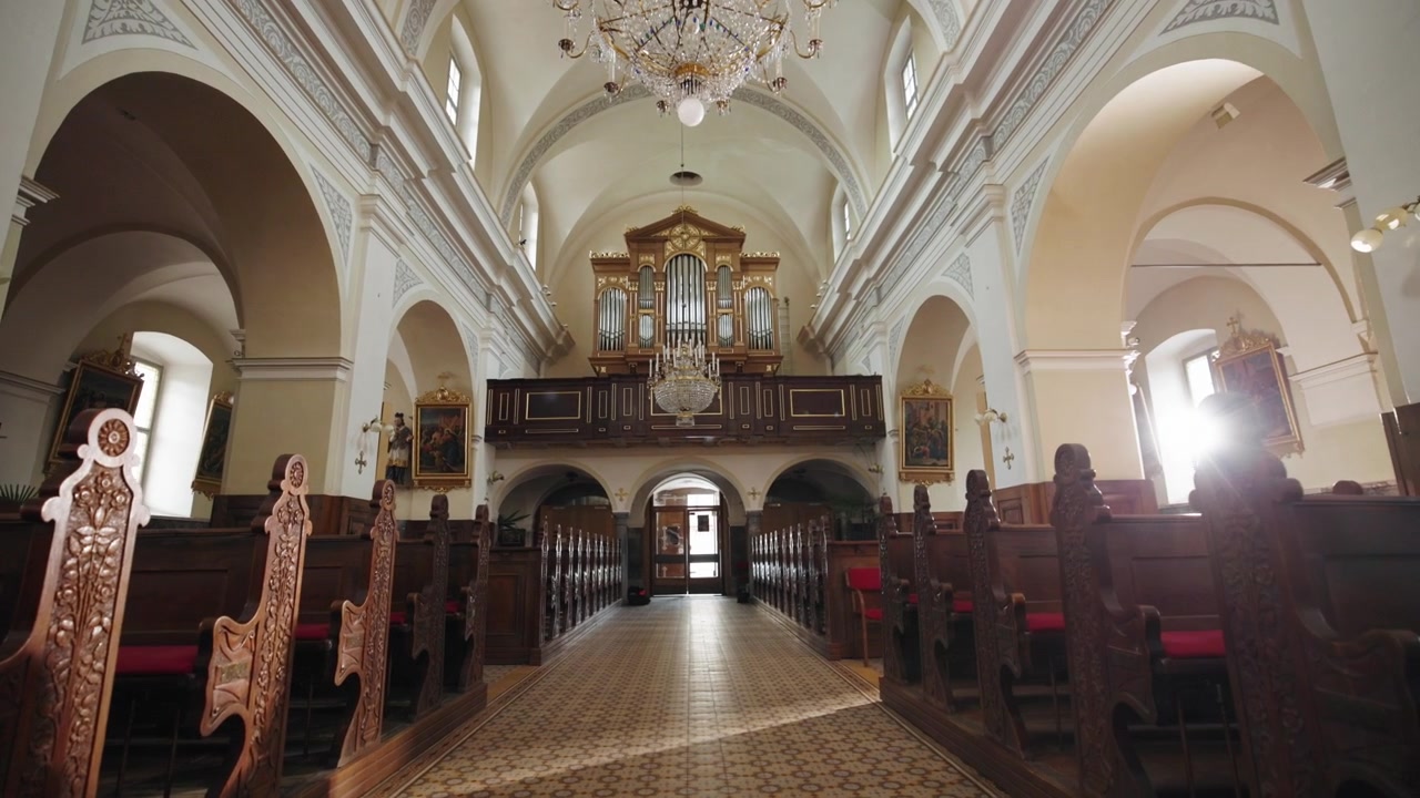 Muovendosi attraverso una chiesa cattolica, camminando lungo la navata centrale verso la porta sul retro