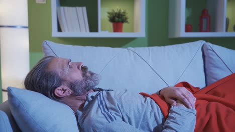 A middle-aged man with a terrible nightmare wakes up from his night&#039;s sleep in a state of anxiety.