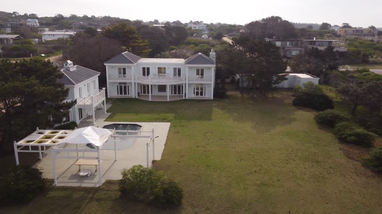 Aerial orbit shot of fancy villa and swimming pool in garden - Jose Ignacio in Uruguay
