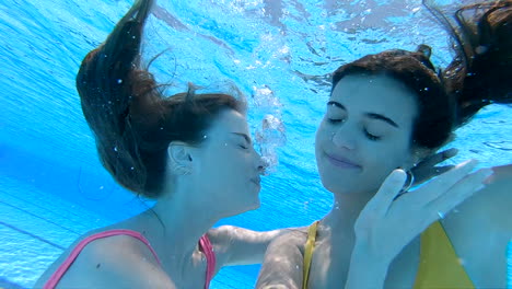 two women kissing underwater