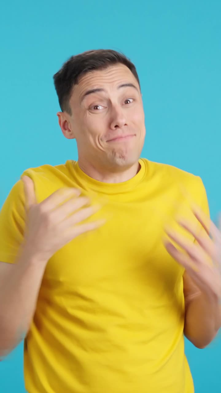 Man in yellow shirt making call me gesture