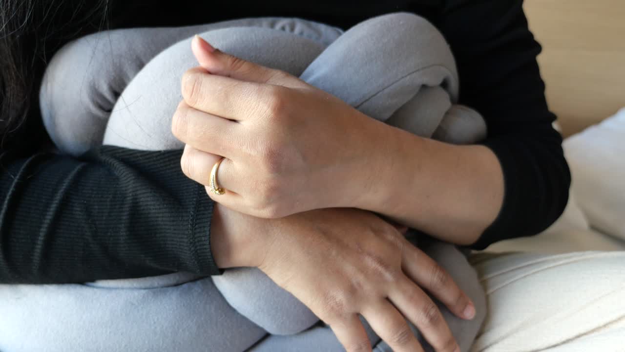 Woman Hugging a Knotted Grey Pillow