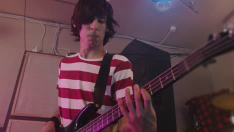 energetic boy playing guitar during a band rehearsal in recording studio