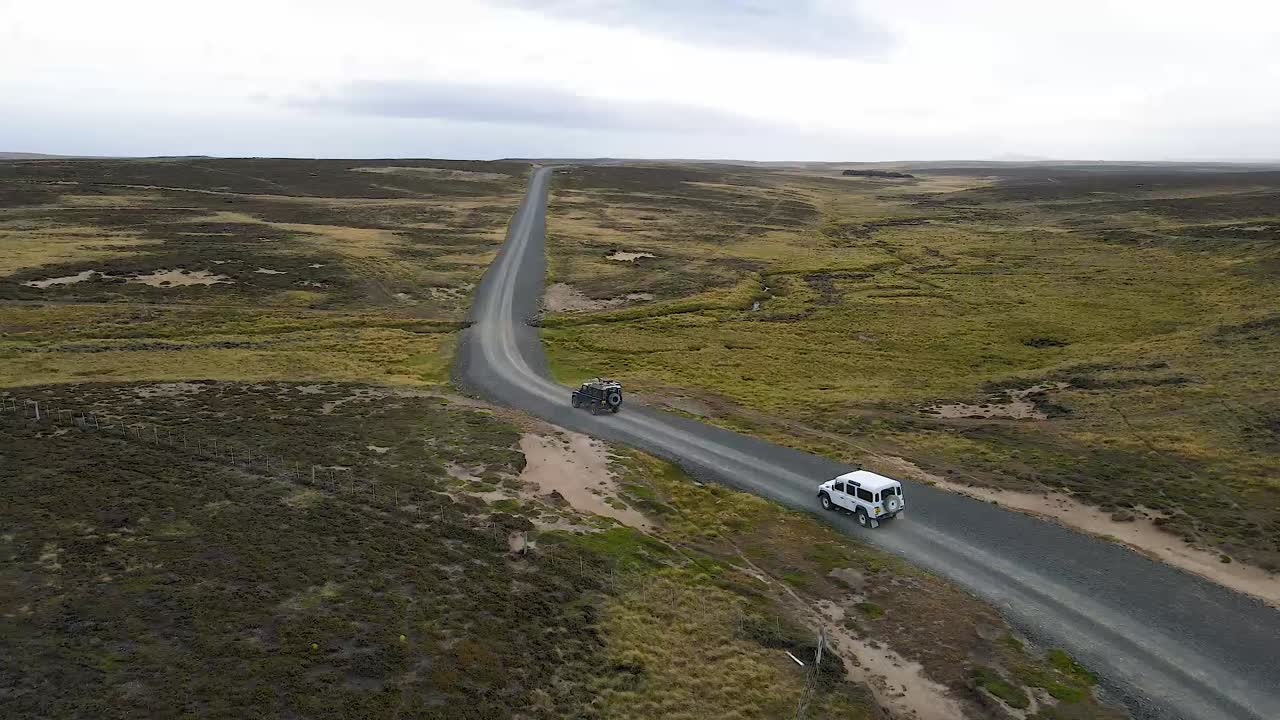 Tourists are driving along a gravel road in their 4x4 vehicles, enjoying the wild patagonian landscape