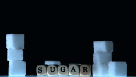 dice spelling out sugar falling beside sugar cubes