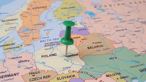 poland - travel concept with green pushpin on the world map. the location point on the map points to warsaw, the capital of the poland.