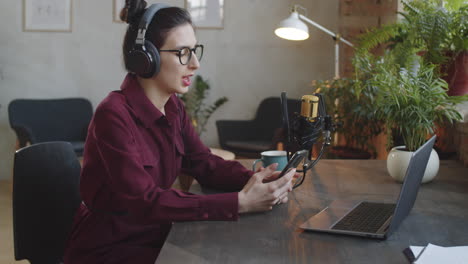 woman reading speech smartphone in podcast recording studio