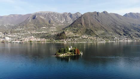 drone slowly rotate around san paolo island on iseo lake during a sunny autumn day