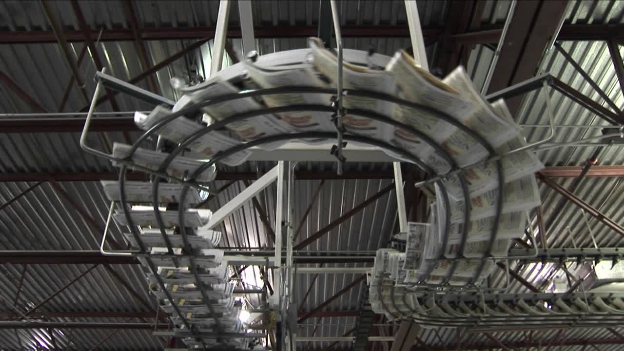 신문 공장의 조립 라인을 따라 신문이 흐릅니다.